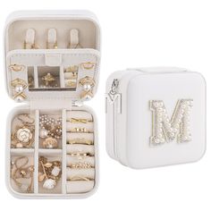 an open white jewelry box filled with lots of rings