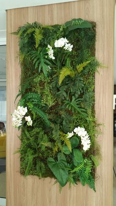 an artificial plant wall with white flowers and greenery