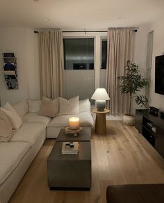 a living room filled with furniture and a flat screen tv on top of a wooden floor