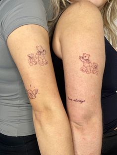 two women with matching tattoos on their arms, one has a teddy bear and the other has a butterfly