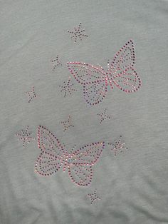 an embroidered t - shirt with butterflies on the front and back, made from beads