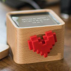 a small wooden box with a red heart on the front and message written in it