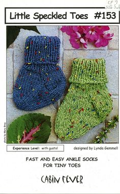 two knitted mittens sitting next to each other on top of a brick wall