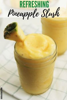 two jars filled with homemade pineapple slush on top of a white tablecloth