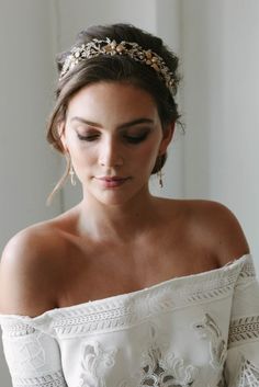 a woman wearing a white dress with a gold headpiece