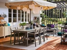 an outdoor dining area with table, chairs and large umbrella over it's head