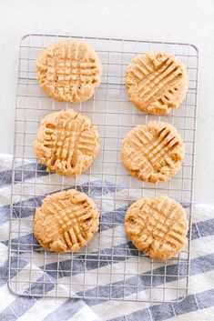 peanut butter cookies cooling on a wire rack next to a glass of milk and spoon