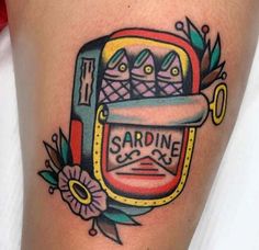 a woman's thigh with an old school style sardine tattoo design on it