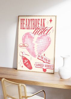 a wooden table topped with a white vase next to a poster