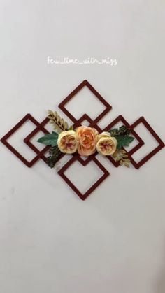 a wall decoration with flowers and leaves in the shape of an interlocked square