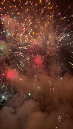 fireworks are lit up in the night sky with colorful lights on it's sides