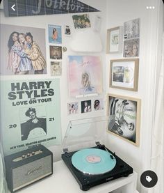 a record player sitting on top of a white table next to pictures and other items