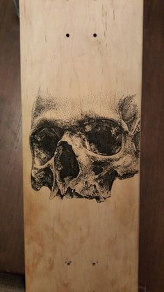 a skateboard with a drawing of a human skull on it's back end