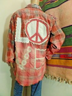 a mannequin with a peace sign on it's shirt hanging up against a wall