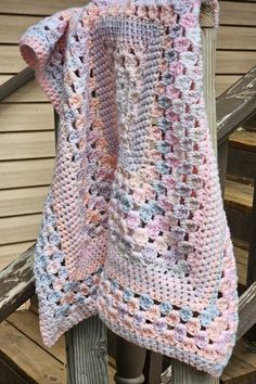 a crocheted blanket sitting on top of a wooden chair