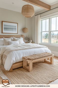 a bedroom with a bed, bench and large window in the corner that overlooks an ocean