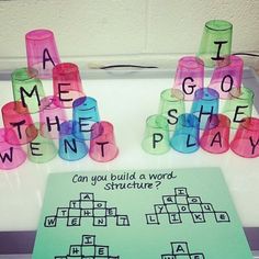 a crossword game is displayed on a table with words spelled out in plastic cups