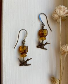 "murmuration ~ vintage-style antique brass bird earrings with earthy tortoiseshell amber, terracotta, wildflower yellow, and gleaming accents Details & measurements: ~ Sweet little antique brass, vintage style bird charms (17 x 7mm) are hanging from  gorgeous small rectangle amber Czech glass beads with an earthy Picasso finish, giving them a tortoiseshell look (12 x 8mm) ~ Accented by Czech glass rondelle spacer beads in matte terracotta (7mm), frosted wildflower yellow colored saucer beads (6mm), and tiny sparkling metallic Czech glass spacer beads ~ They hang from antique brass ear wires ~ Earrings hang approx. 1 3/4\" long ♡ Packaged safely & sustainably in a kraft box with cotton ribbon & dried organic florals. This makes for a beautiful gift, or something pretty for yourself! All pac