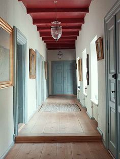 an empty hallway with blue doors and red ceiling