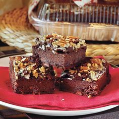 three pieces of brownie on a plate next to a glass dish with bread in the background