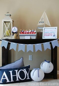 a table topped with lots of pillows and other items next to a sign that says ahoy