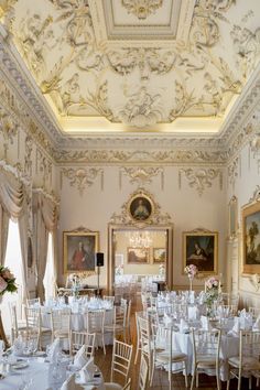 a room filled with tables and chairs covered in white linens