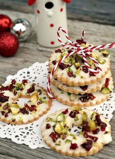 cookies decorated with white icing and dried pistachios on a doily