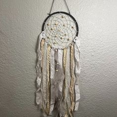 a white dream catcher hanging on the wall