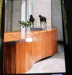 a cell phone with an image of two horses on top of a wooden table in front of a window