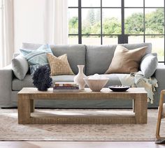 a living room scene with focus on the couch and coffee table in front of the window