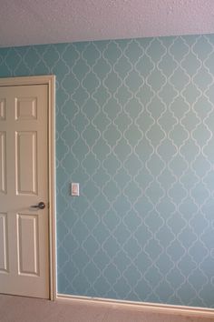 an empty room with blue wallpaper and white door