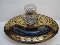 an antique glass and brass toothbrush holder