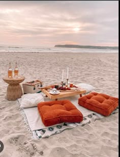 an orange blanket on the beach with food and drinks