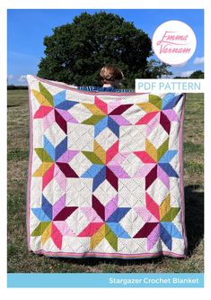 a woman holding up a colorful quilt in front of a tree with the words, stargazer crochet blanket