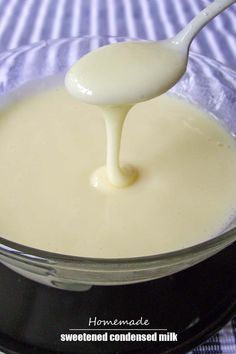 a spoon is being used to mix cream in a bowl