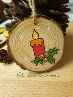 a wooden slice with a candle on it and pine cones around the edges, sitting on top of a table