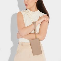 The Zana Foldout Wristlet Wallet is an elevated style that features a classic, minimal design with vegan leather details, gold-tone hardware and a detachable keychain. While the interior includes a wide note slot and zip compartment to store all of your small essentials. The ultimate day-to-night accessory. Details Color: Soft Tan Dimensions: 4.375" x 0.75" x 7.5" Strap Length: 15" Fold Out Wristlet Wallet Wristlet Pouch, Scented Sachets, Photoshoot Model, Elevated Style, Candle Gift Set, Wristlet Purse, Fragrance Diffuser, Candle Accessories, Wristlet Wallet