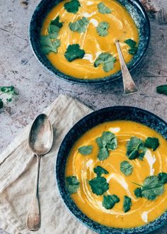 two bowls filled with soup and garnished with cilantro