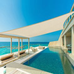 an outdoor swimming pool next to the ocean