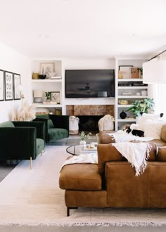 a living room filled with furniture and a flat screen tv mounted on the wall over a fireplace