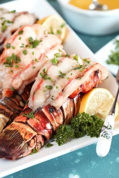 lobsters are served with lemon wedges and parsley garnish on the side