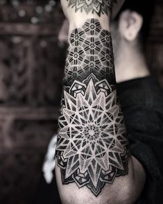 a man's arm with an intricate tattoo design on it