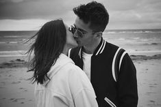 a man and woman kissing on the beach