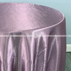 a round table covered with a shiny purple cloth