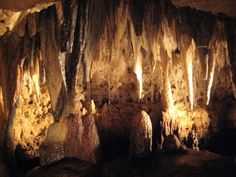 the inside of a cave filled with lots of stalate and rock formations at night