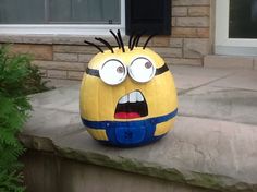 a large yellow and blue pumpkin sitting on top of a cement step