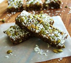 three pieces of chocolate and pistachio bars on top of a wooden cutting board