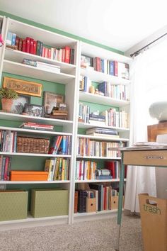 a book shelf filled with lots of books next to a window