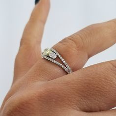 a woman's hand with a diamond ring on top of her finger and an engagement band in the middle