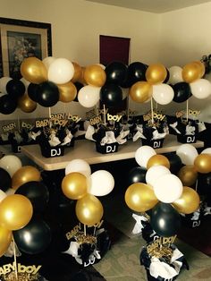 black, white and gold balloons are on the table